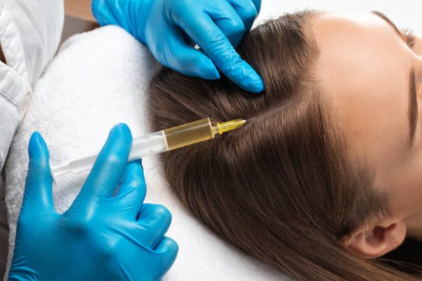 Cosmetologist does injections therapy against hair loss and anti-dandruff of a beautiful woman in a beauty salon. Cosmetology concept.